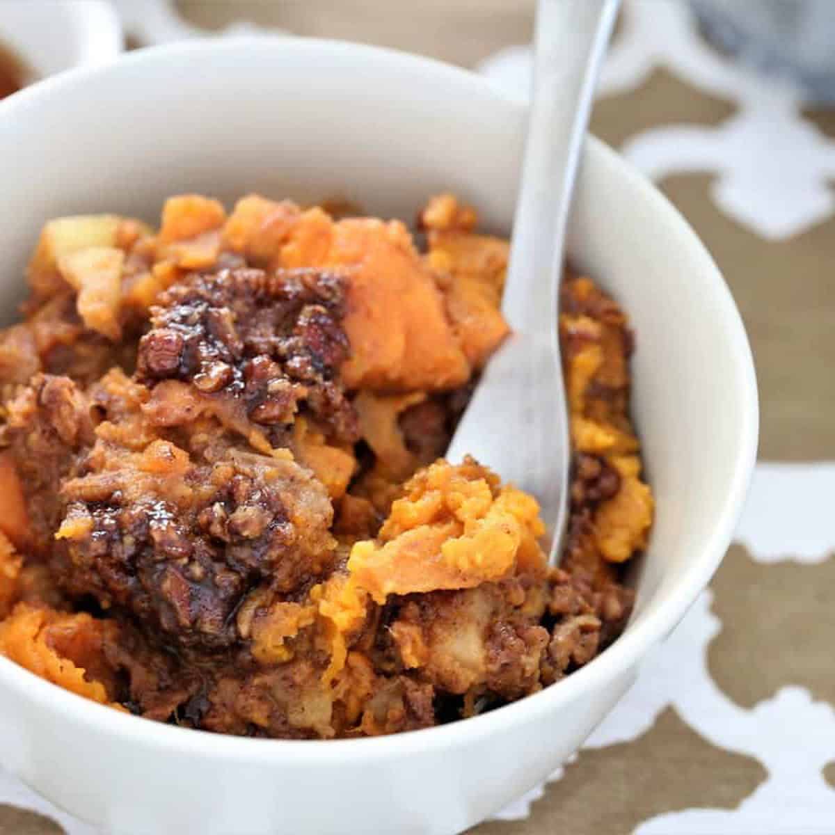 Grafted pro savory sweet potato casserole with pecans in a white bowl close-up.