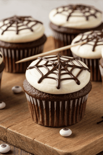 Chocolate cupcake with spiderweb decoration and white frosting, perfect for Halloween treats. Deliciously decorated for themed parties or spooky celebrations.